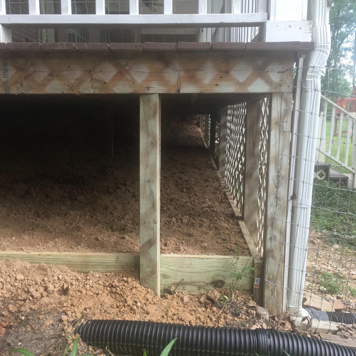 A Best Foundation Repair inspecting drainage and foundation work under a Houston home