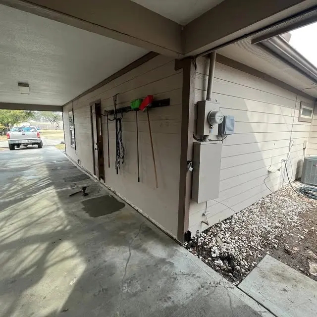Residential foundation perimeter showing concrete and drainage conditions around a Humble home. Proper grading and moisture management help reduce soil movement that can contribute to foundation settlement.
