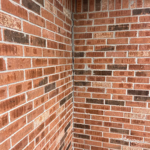 Brick wall separation at the corner of a residential home showing a visible sign of foundation movement. Gaps in exterior masonry can indicate settling that may require a professional foundation inspection.
