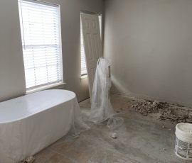 Bathroom fixtures wrapped and protected while house leveling work goes on underfoot