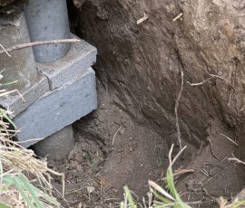 Concrete pier and block cap set underneath a settled slab edge