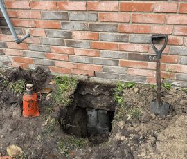 Hydraulic jack in place beside the foundation, ready to lift this section back to level